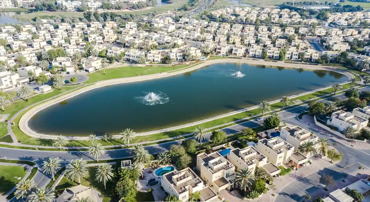 Aerial photograph of a landscaped villa community with a central lake in Dubai