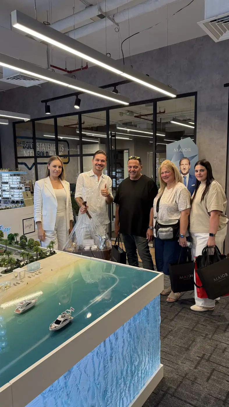 Clients and a ProEstate broker at a developer sales gallery in Dubai: Major Developments